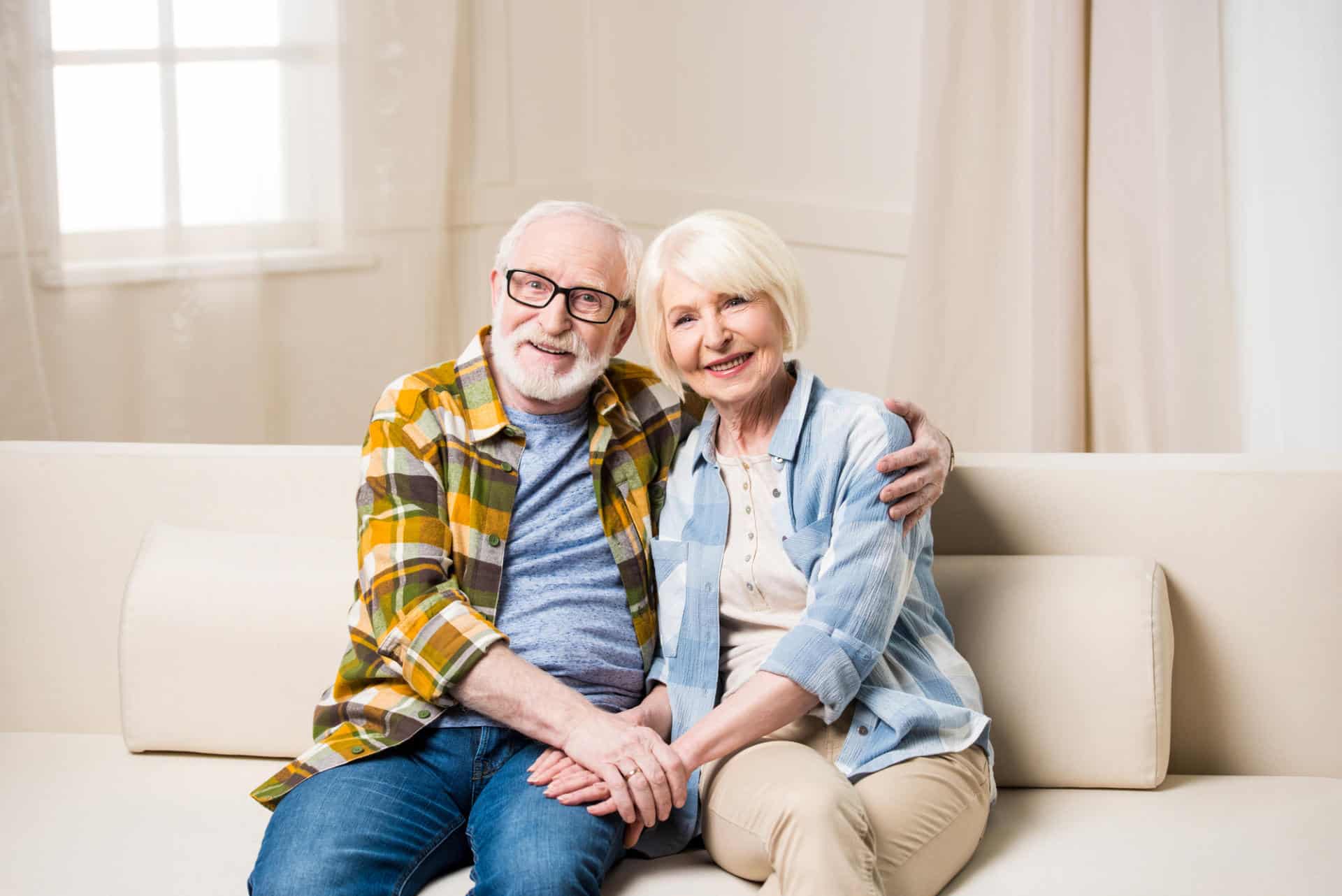 Elderly man and woman embracing on couch